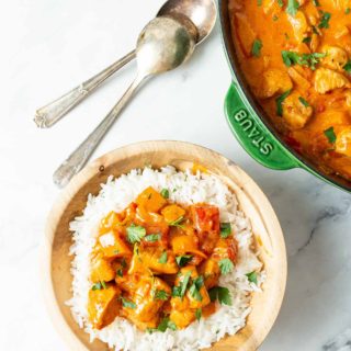 Chicken Paprikash over a bed of rice in wooden bowl