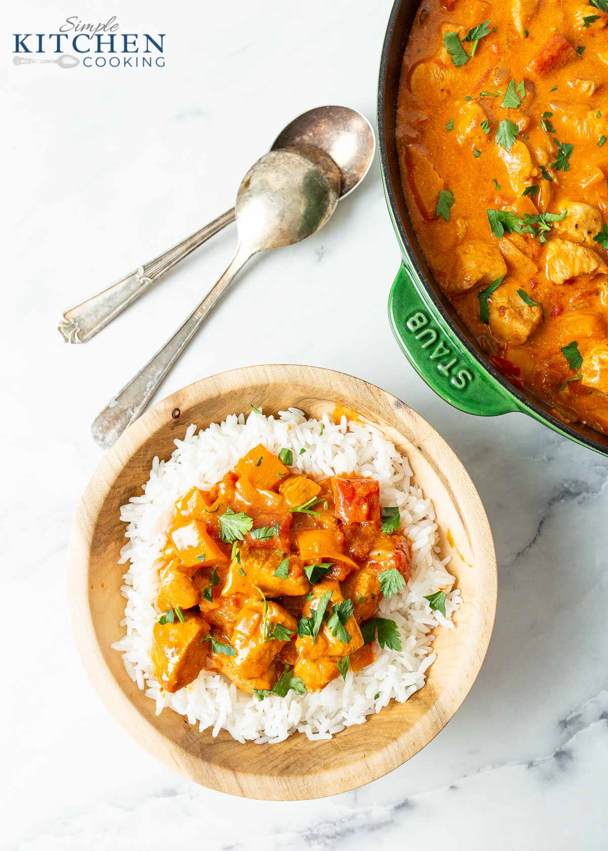 Chicken Paprikash over a bed of rice in wooden bowl